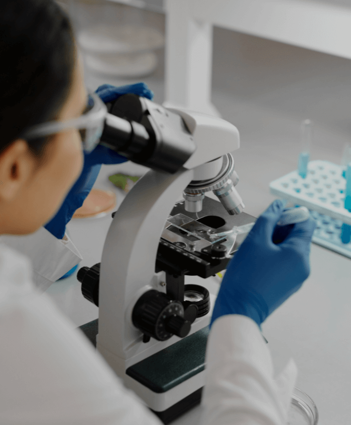 Scientist in laboratory with microscope 