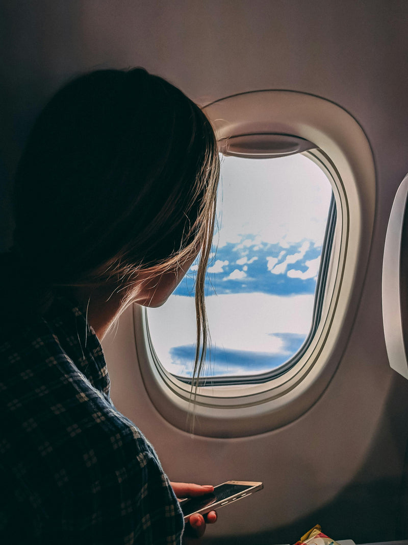 Woman on aeroplane. Managing rosacea on aeroplanes
